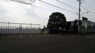 村山工場の正面入口だった場所。右手のガラス張りの建物はショールームだった。現在は某宗教法人が所有