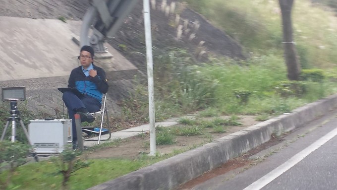 ここまで近づくと分かりますが、ここでレーダーに気付いたって「時既に遅し!」です。無線で「はい“わ”ナンバーの白のカローラ」とこの先に控えている取り締まり軍団に伝えられ、手持ちの「止まれ」の旗に止められて、あえなく御用となる訳です。
