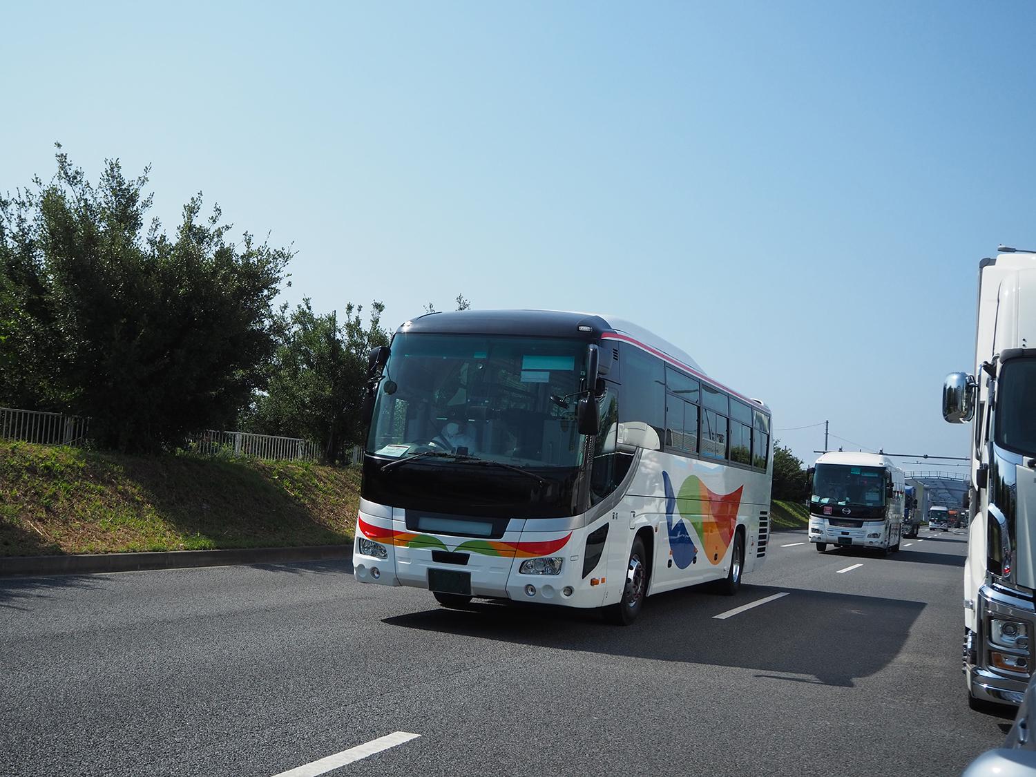 オリンピック関係者輸送用に手配された地方の観光バスの走行シーン