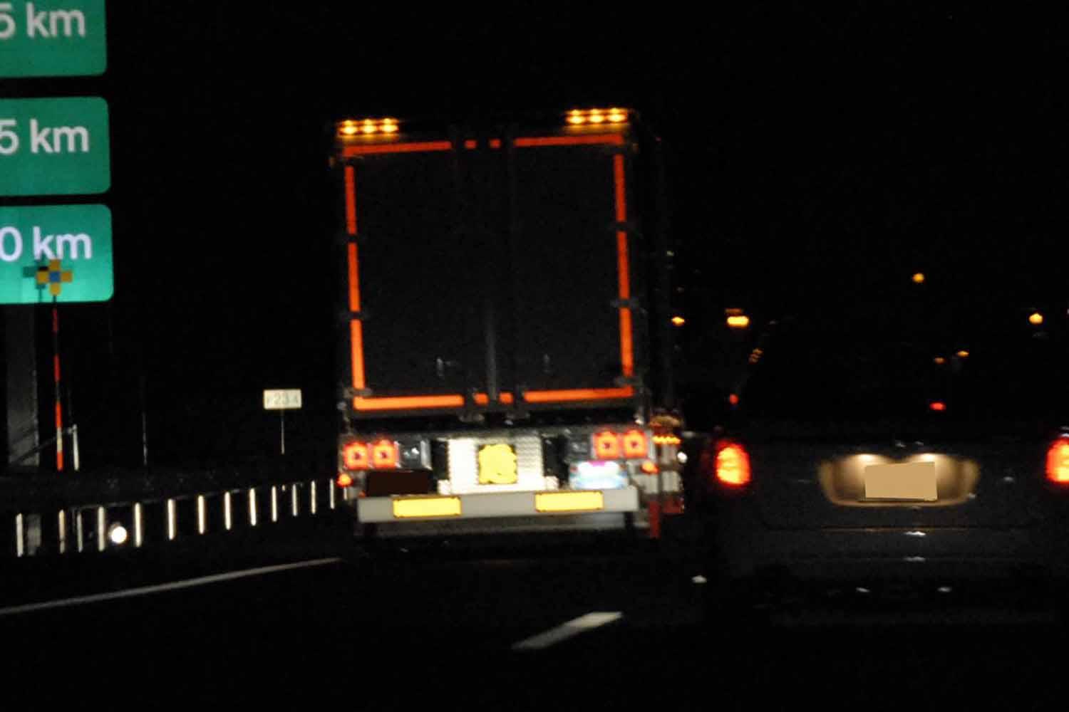 高速道路で夜間走行するトラックのイメージ