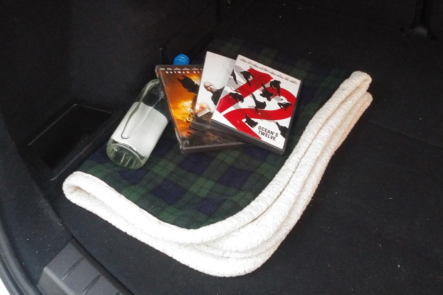 ロシアの車のトランクに積まれている毛布とDVDとウォッカのイメージ