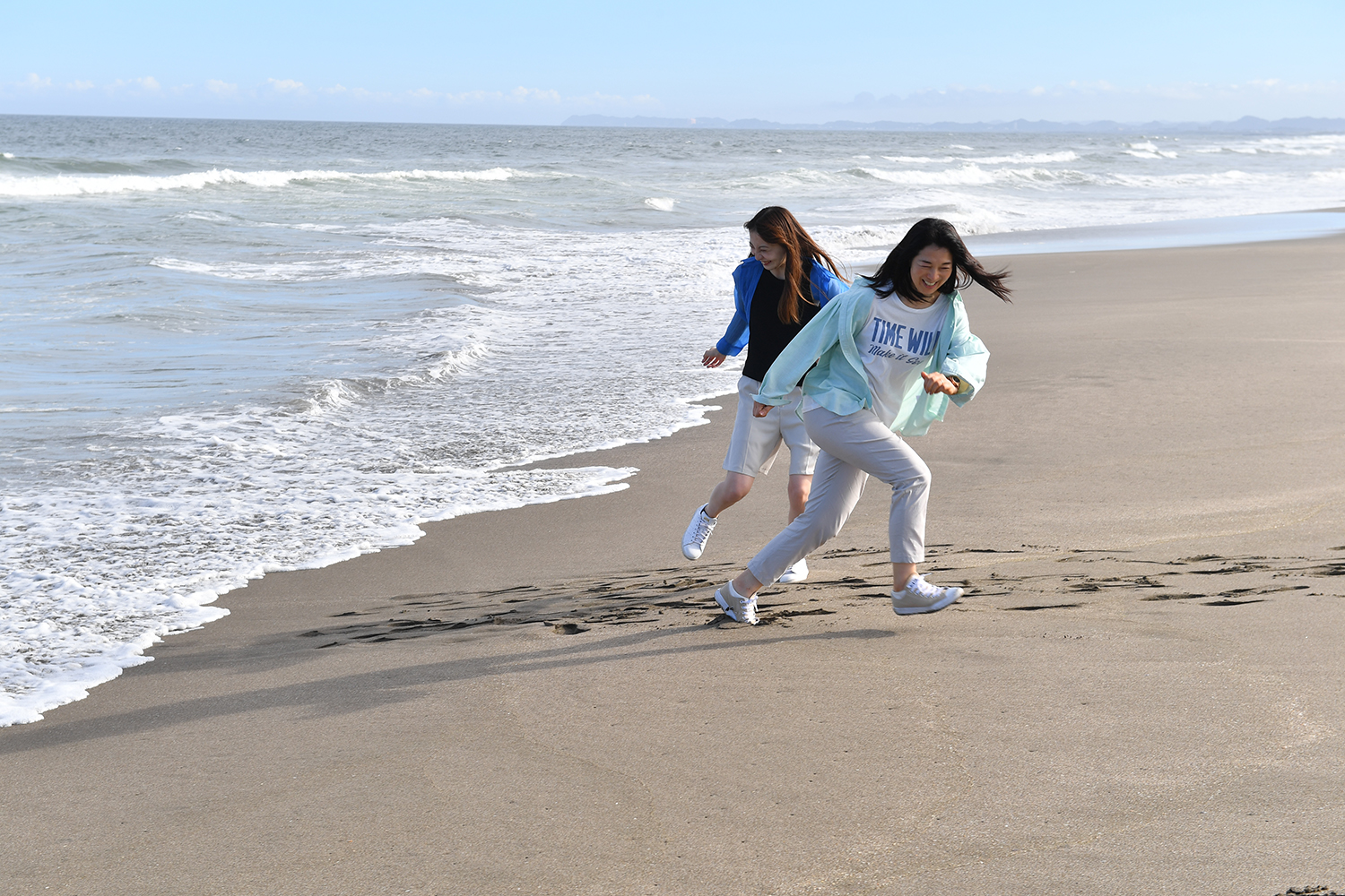 波と戯れる女子２人