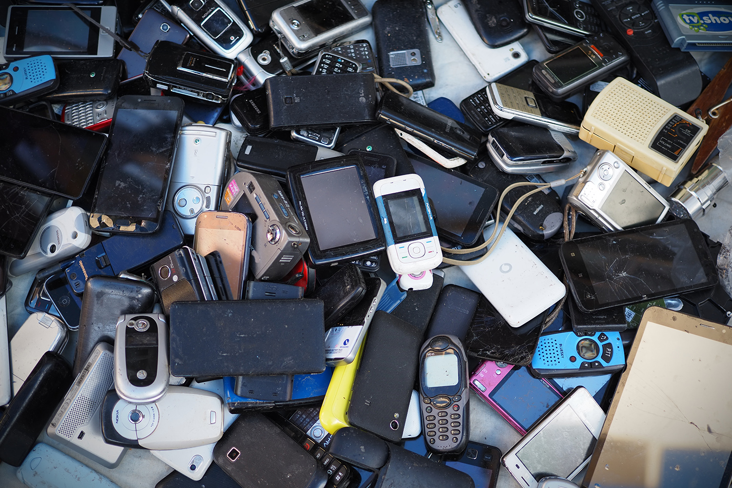 使い捨てられたスマートフォンや携帯電話の山