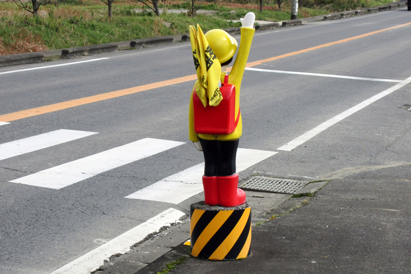 横断歩道手前の手を上げている人形