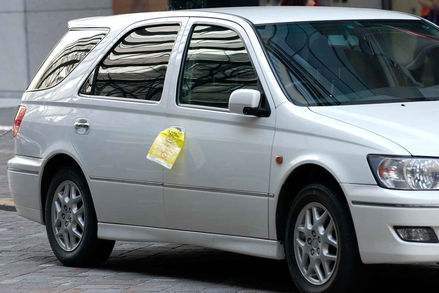 駐車違反の鍵付き標章を取り付けられたクルマ