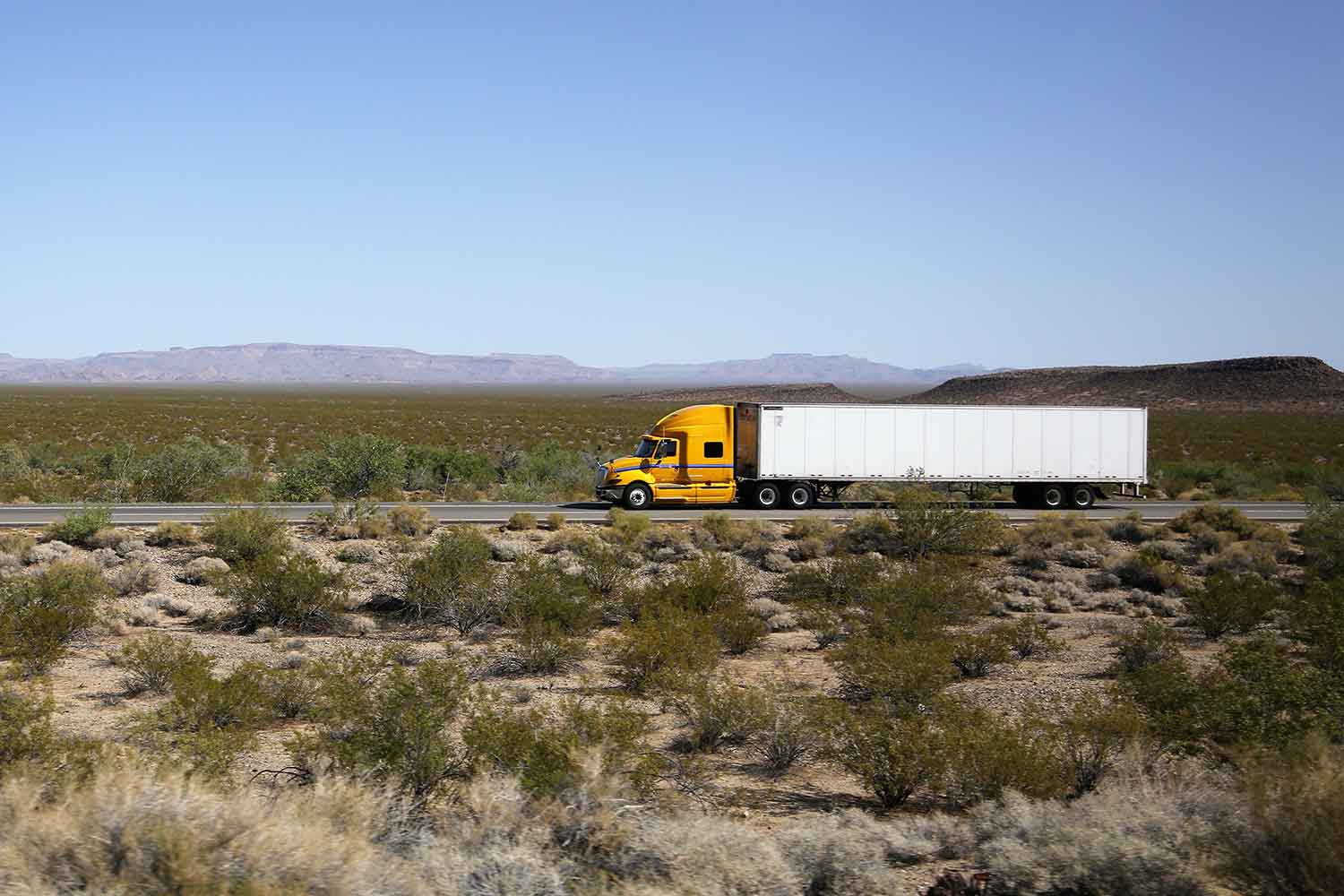 砂漠地帯のフリーウェイを走行するトレーラーのイメージ写真