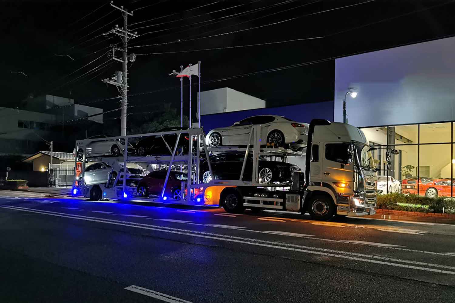 夜間のディーラーの側に駐車しているキャリアカーのイメージ写真 〜 画像3