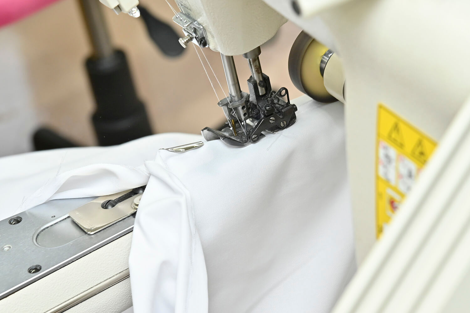 ホンダの白い作業着の3本針ミシンによる縫製