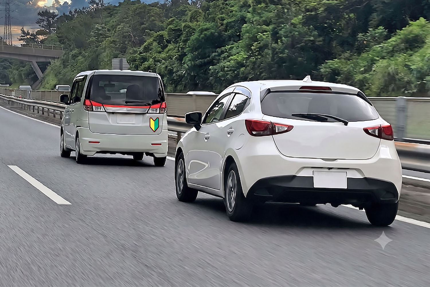 写真車マークのクルマをあおる後続車
